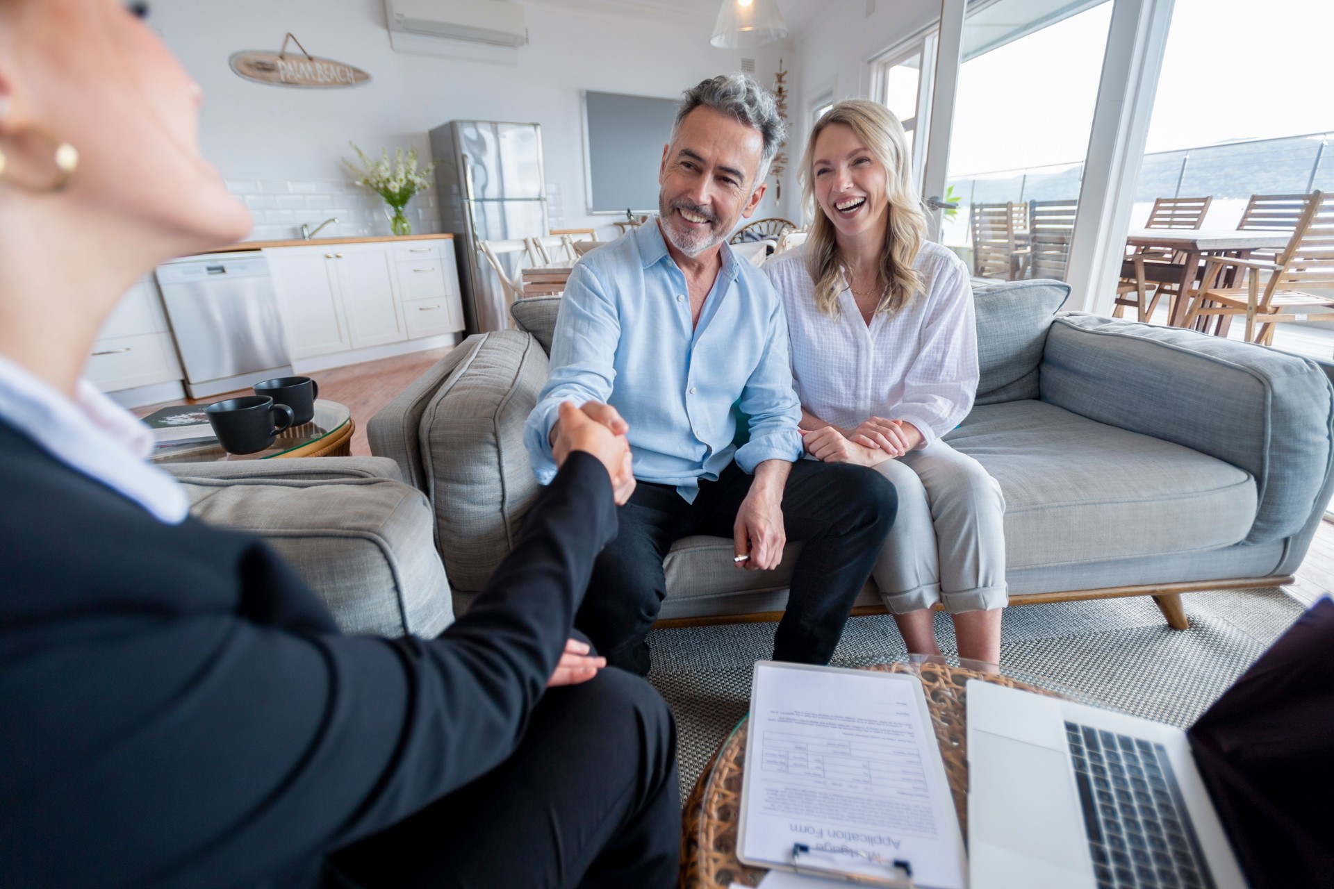 Happy mature couple meeting investments and financial advisor at home.